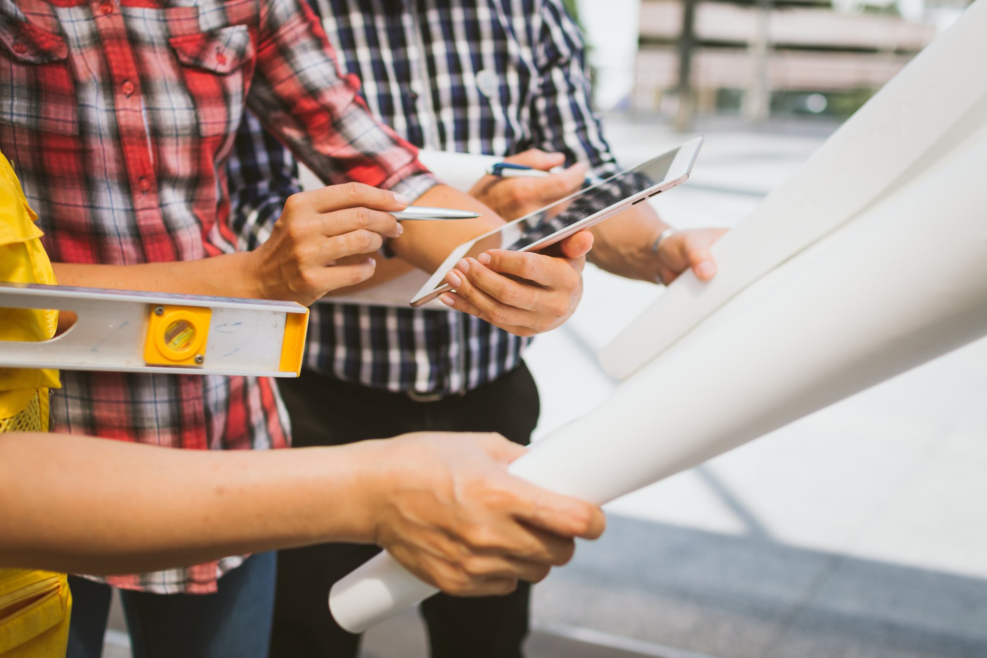 workers-holding-digital-devices-and-blueprints