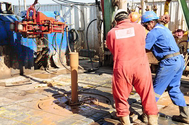 drilling-rig-workers-making-machine-connection drilling-rig-workers-making-machine-connection