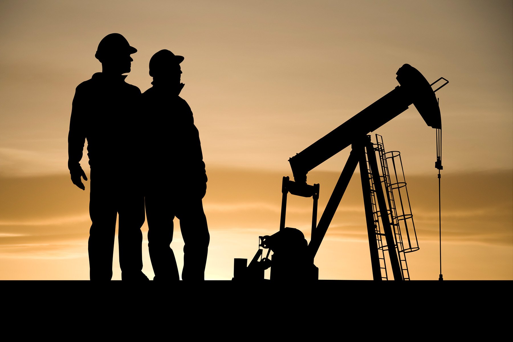 silhouettes-of-oil-industry-workers-standing-in-front-of-a-fracking-machine