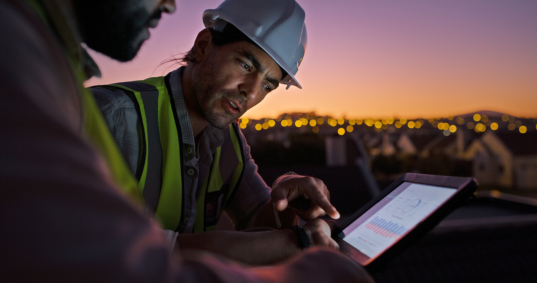 workers-discussing-metrics-on-digital-device workers-discussing-metrics-on-digital-device