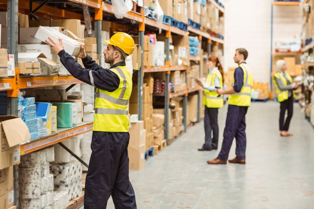 Warehouse worker taking package in the shelf in a large warehouse in a large warehouse Warehouse worker taking package in the shelf in a large warehouse in a large warehouse